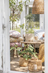 Rattanbord med hylde i udestue/overdækket terrasse med kurvestole