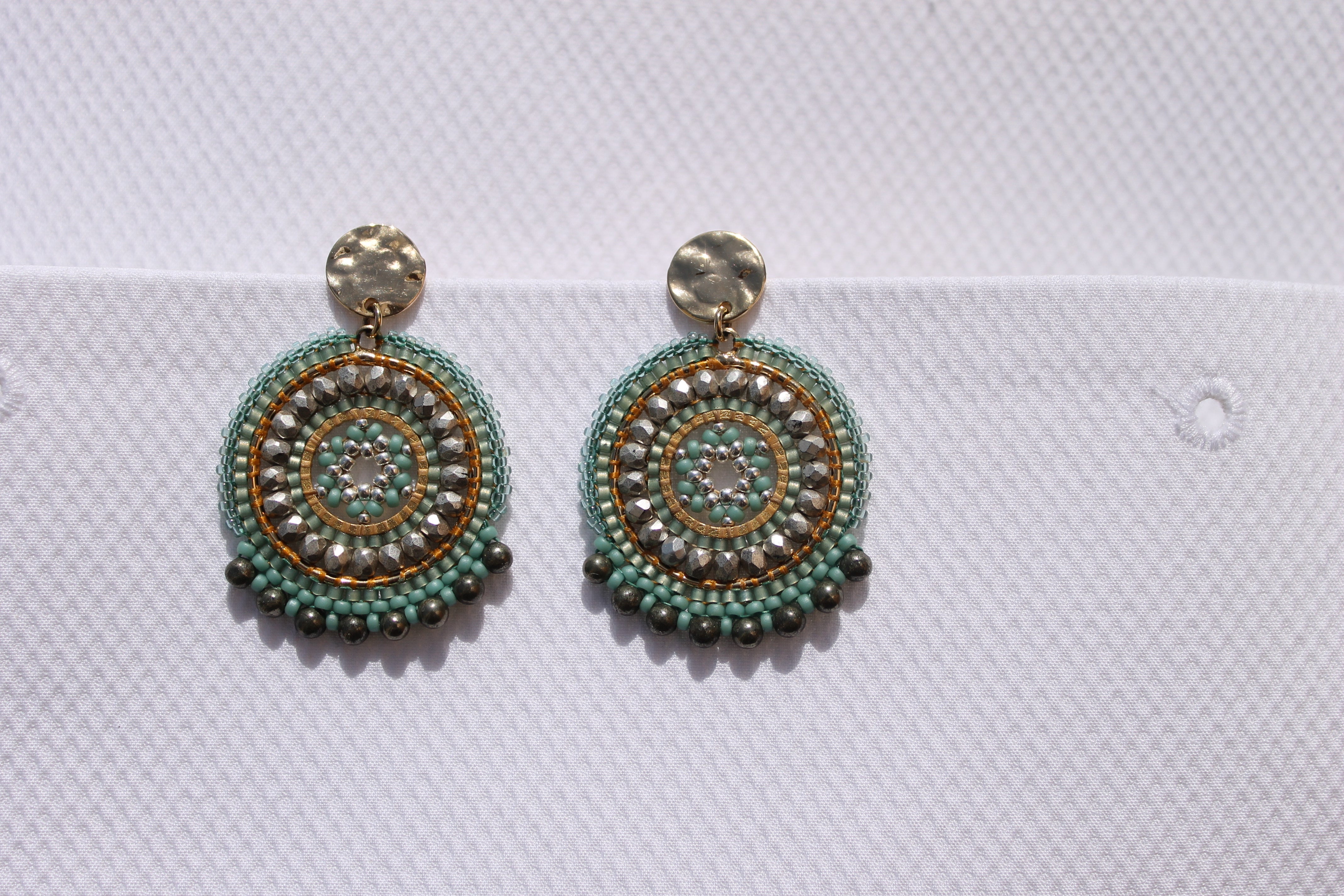 Runde forgyldte øreringe fra Maq Jewelry med turkis og grå sten